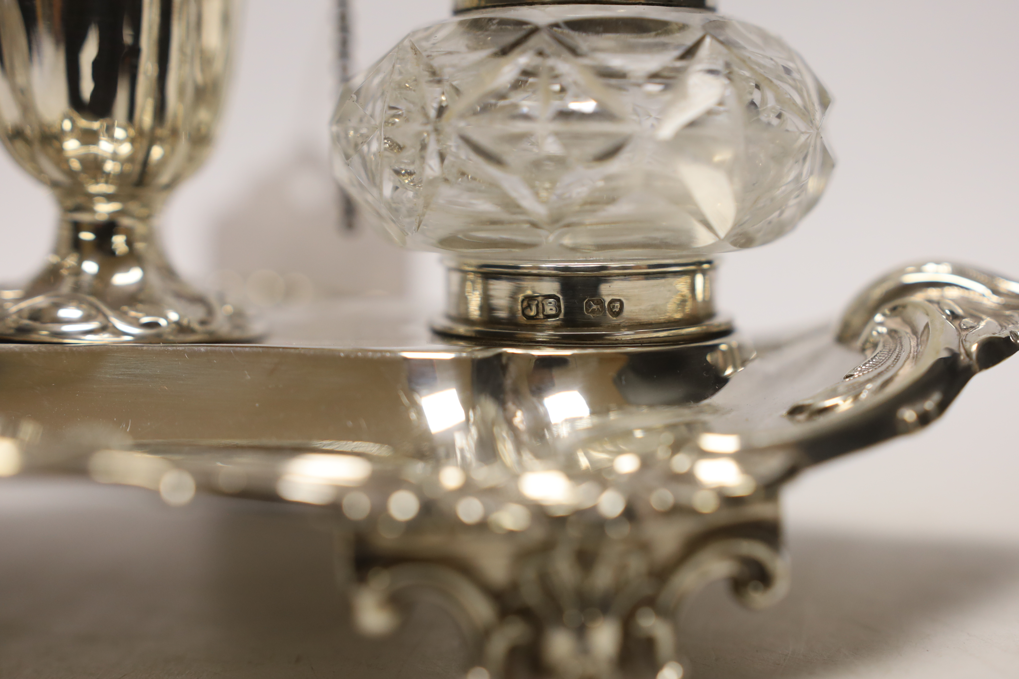 A Victorian silver inkstand, with two mounted glass wells and central removable chamberstick, John Brashier?, London, 1890, 23.4cm, 9.6oz (a.f.).